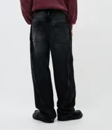 Pantalón de jean corte super baggy, de color azul claro con efecto lavado. Presenta un diseño de pierna ancha con costuras laterales destacadas con detalles deshilachados y bolsillos funcionales.
