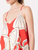 Vestido midi de algodón estampado color rojo con dibujos de abanicos en blanco y negro. Tiene escote en V, breteles finos regulables, espalda baja y bolsillos laterales.