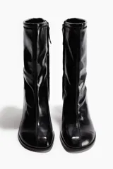 Botines negros de diseño ajustado con acabado brillante, punta cuadrada, costura frontal central y tacón grueso.