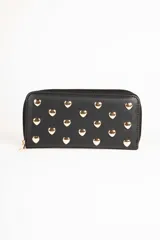 Billetera negra con cierre perimetral y apliques de tachas doradas en forma de corazón en el frente.