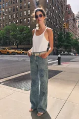 Jeans de tiro alto con corte flare y diseño de tejido jacquard con patrón floral. Presenta cinco bolsillos, trabillas en la cintura y cierre frontal con cremallera y botón.