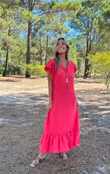 Vestido largo color rojo con escote en V, mangas cortas con volados y falda con volado en el ruedo.