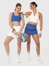 Top blanco con diseño cuello polo, corte cropped, sin mangas y espalda deportiva. Ideal para jugar pádel o tenis.