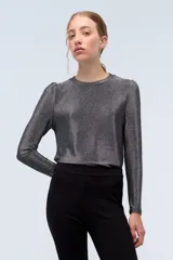 Remera plateada de lurex con escote redondo, calce al cuerpo y mangas largas estilo princesa.