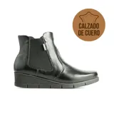 Bota tipo botineta de cuero negro con diseño de elástico lateral, suela de goma con taco corrido y acabado texturizado.