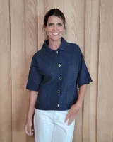 Cardigan de lana lambswool color azul oscuro, con cuello clásico, cierre frontal de botones y mangas cortas con terminación acanalada. Presenta dos bolsillos frontales y diseño de punto tejido.