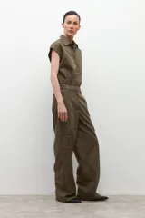 Mono de estilo utilitario color verde oliva, con cuello camisero, cierre frontal con botones, mangas cortas y bolsillos tipo cargo.