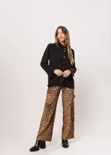 Camisa negra de cuello redondo con frunces y mangas largas con puños abiertos.