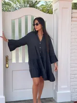 Vestido amplio de lino color verde lima, con cuello mao y abertura frontal con botones de coco. Presenta un diseño con canesú fruncido y volados en los puños de las mangas largas.