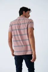 Remera tipo polo de manga corta, color rosado con rayas horizontales en tonos azul y blanco. Cuenta con cuello clásico, cierre frontal de tres botones y logo estampado en el pecho.