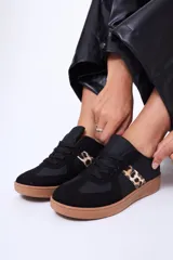 Championes urbanos de diseño clásico, color negro con detalles en animal print de leopardo en los laterales. Presentan suela de goma color caramelo y cierre mediante cordones.