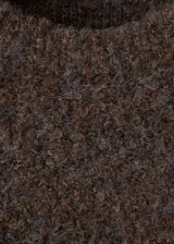 Chaleco de tejido bouclé color marrón, con cuello redondo y manga corta. Presenta un diseño recto y textura suave.