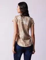 Remera color beige con estampado de hojas blancas, cuello redondo y mangas cortas.