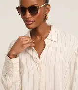 Camisa de viscosa y lino color crudo con finas rayas verticales azules, cuello clásico, mangas largas con puños abotonados y cierre frontal con botones.