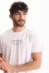 Remera blanca de algodón, de corte regular y manga corta, con estampa frontal centrada con texto en tonos oscuros.