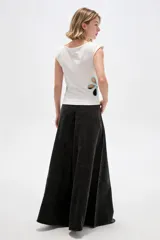 Remera de poliéster color blanco, de corte ajustado, con cuello bote, mangas sisa y detalles de aberturas (cut-out) en los costados con apliques florales en tono celeste.