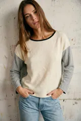 Sweater de tejido de punto con diseño bicolor, cuerpo en color crema y mangas en gris melange, con cuello redondo en contraste negro.