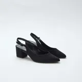 Zapatos de tacón medio y grueso color negro, con diseño destalonado, punta fina y tira ajustable con hebilla en el talón.