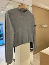 Remera de morley color mostaza, de manga larga, con cuello alto fruncido y terminaciones fruncidas en las mangas.