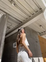 Top beige a rayas verticales, con escote halter y lazos ajustables en el frente y la espalda.