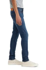 Pantalón de jean azul oscuro, corte skinny taper con tiro medio.