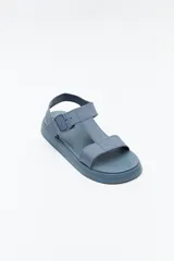 Sandalia baja negra con tiras anchas y hebilla lateral.