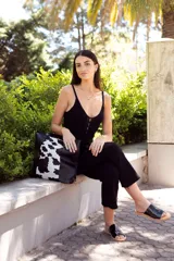 Sandalias bajas negras de cuero charol, con base color suela y diseño minimalista.