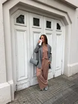 Conjunto compuesto por remera de manga larga y pantalón largo, confeccionados en tejido rib con diseño de rayas horizontales.