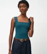 Blusa básica sin mangas marca Cortelle, confeccionada en poliamida con elastano. Presenta un diseño ajustado al cuerpo con escote cuadrado tanto en el frente como en la espalda y breteles medianos.
