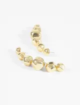 Aros largos dorados con borlas colgantes.