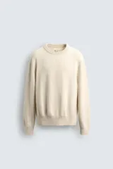 Jersey de punto relaxed fit confeccionado en mezcla de lana y fibra de alpaca, con textura ligera y efecto pelo. Presenta cuello redondo, manga larga y acabados en rib en puños y cintura.