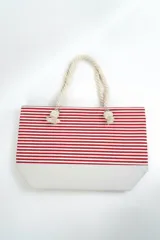 Bolso tipo tote de playa, con diseño a rayas horizontales en color rojo y blanco, y base de lona color beige. Cuenta con asas de mano confeccionadas con soga gruesa de algodón y terminaciones con nudos.