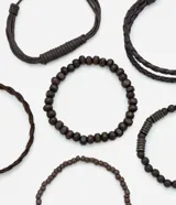 Kit de seis pulseras masculinas de color negro con distintos diseños, incluyendo modelos trenzados con cierre ajustable y modelos de cuentas de madera y vidrio.