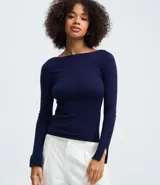 Suéter de punto ajustado con escote canoa y mangas largas. Presenta una superficie lisa y acabado clean, confeccionado en una mezcla de viscosa, poliéster y poliamida.