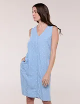 Vestido corto azul con estampado de lunares blancos, silueta evasé, sin mangas y escote en V con bolsillos laterales.