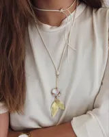 Collar largo con cordón de cuero crudo, dije de bronce y nácar con forma de hojas y cristal facetado.