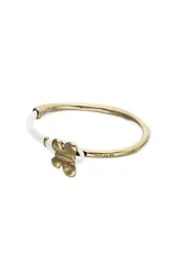 Pulsera semirígida con estructura de cuero color crema y detalle central de mariposa metálica bañada en oro 18k. Presenta un diseño minimalista con el logo de la marca grabado en uno de los extremos metálicos.