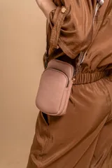 Bandolera compacta color rojo con textura de cuero, correa regulable y desmontable con diseño de rayas rojas y blancas. Cuenta con bolsillos frontales y cierre, interior forrado en tela.