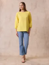 Blusa amarilla texturada con escote redondo y mangas 3/4 con puño elastizado. Aplique de broderie en escote y mangas. Marca Ruby Rd.