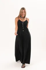 Vestido largo de denim fino y liviano color negro, de breteles finos, escote delicado, silueta entallada arriba y falda amplia con bolsillos laterales.