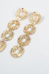 Aros colgantes largos compuestos por cuatro eslabones circulares texturizados con diseño de rayos en el borde y centro calado.