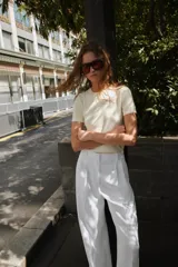 Jersey de punto color rosado claro, con cuello redondo y manga corta. Presenta una textura suave y un acabado ligeramente jaspeado.