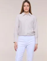 Camisa de calce relajado color celeste, confeccionada en tejido de textura suave y fluida. Presenta cuello camisero y abotonadura frontal, mangas largas con puño ancho y ruedo curvo.