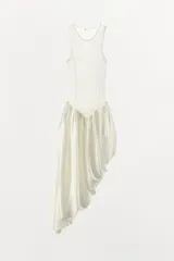 Vestido midi color blanco, de punto fino con cuello redondo y tirantes. Presenta una silueta ajustada en la parte superior y una falda asimétrica con volumen y frunces.