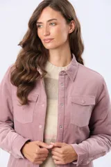 Campera de pana color rosado con interior de corderito sintético. Cuenta con cierre frontal de botones metálicos, cuello camisero, bolsillos con solapa en el pecho y mangas largas.