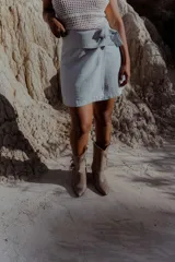 Bota texana de caña media color marrón, confeccionada en cuero gamuzado, con punta marcada, taco de 6 cm y flecos laterales.