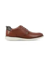 Zapato de cuero color marrón con cordones, diseño de estilo derby y suela blanca de goma tipo deportiva.