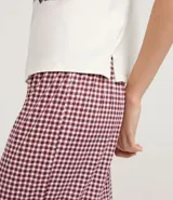 Pijama largo de dos piezas, confeccionado en malla suave con tecnología Peach Touch. Incluye una blusa de manga corta color blanco con estampado frontal de la palabra "LOVE" en tonos pastel y un pantalón de cuadros vichy en color bordó y blanco, con cintura elástica.