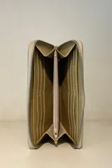 Billetera de charol color cereza con textura tipo cocodrilo y cierre perimetral con cremallera.