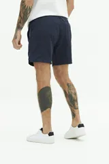 Short de baño liso con cintura elástica y cordón ajustable. Cuenta con dos bolsillos laterales, un bolsillo trasero y logo bordado en el ruedo. Confeccionado en tejido ligero de secado rápido.